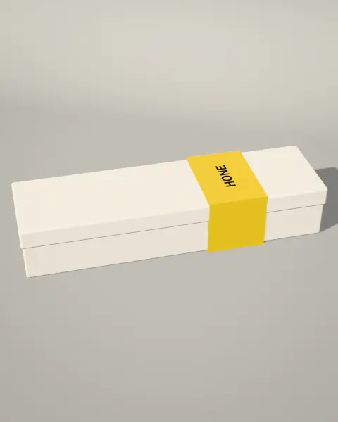 A long bone-white box with a lid, held by a yellow paper band printed Hone.