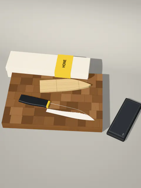 The knife, its sheath, the diamond plate, the end-grain board and the gift box arranged together on the studio floor.